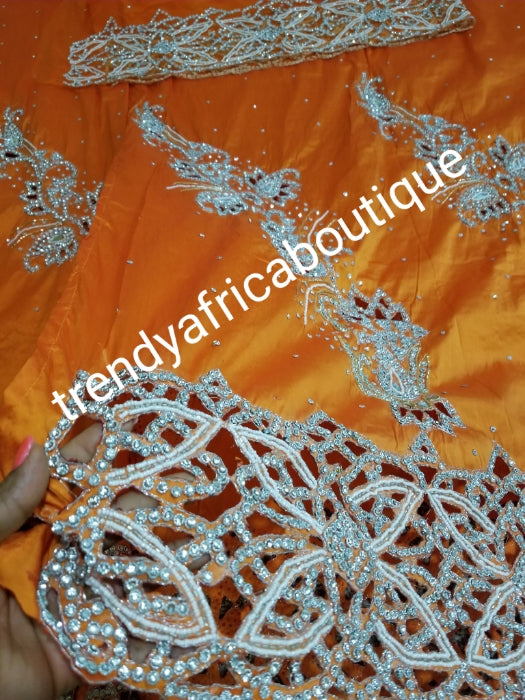 Nigerian traditional wedding . Beautiful orange Niger/Igbo/delta traditional wedding George wrapper. hand stoned with dazzling crystal stones to perfection. for special occasion. 2.5yds + 2.5yds + 1.8yds net blouse. Beautiful handcut border.