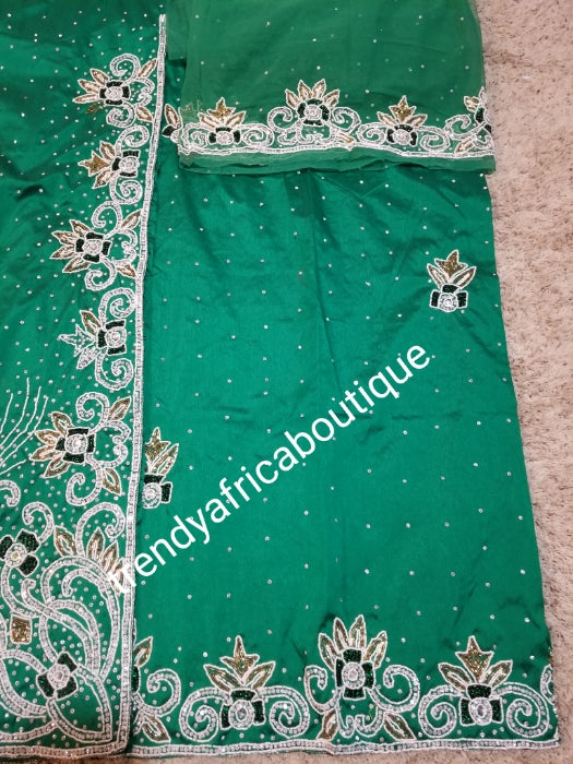 Special offer Nigerian Traditional wedding hand stoned Raw silk George Wrapper and matching net blouse. beautiful Green color embellished with crystal stones. Beaded and stoned on the side border top wrapper. Model shown wearing blue same design
