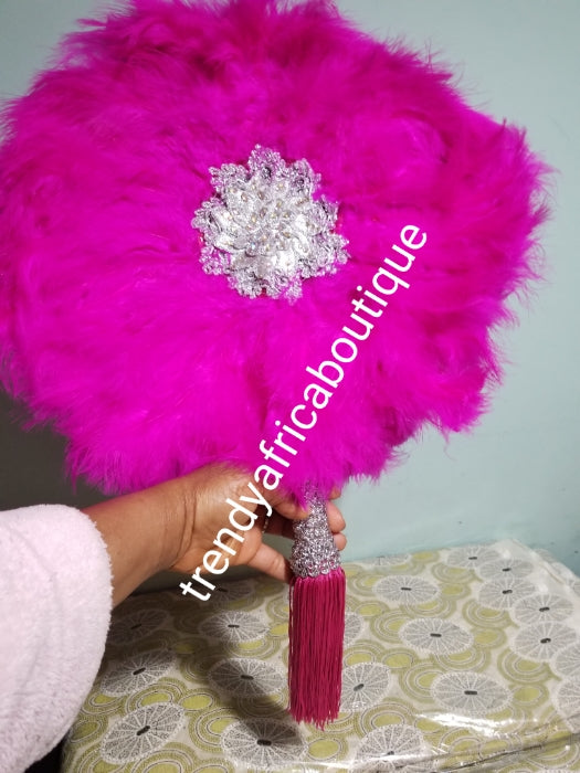 fluffy feather hand fan in beautiful fuchsia pink feathers, embellished with silver accessories. Nigerian traditional Bridal Accessories hand fan for celebrant. Fully handmade with silver handlel & matching pink tassels. Round fluffy feathers hand fan