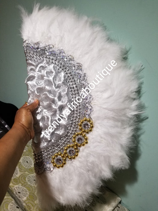 Back in stock. Pure White/silver Feather hand fan. Large moon shape hand fan Nigerian Bridal-accessories front and back middle design with beads and flower petal. Limited quantity. 25" long + 14" wide. Small handle to hold your fan. Very class