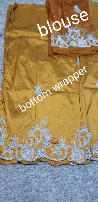 Exclusive design. Gold silk George wrapper beaded and stoned with white/silver. Nigetian traditional wedding George wrapper. Top quality at a special price. Sold 5yds +1.8yds matching net blouse