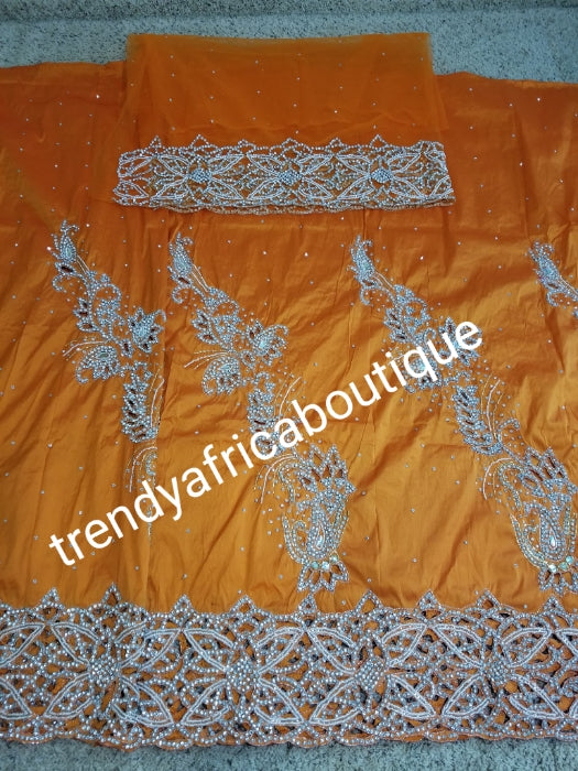 Nigerian traditional wedding . Beautiful orange Niger/Igbo/delta traditional wedding George wrapper. hand stoned with dazzling crystal stones to perfection. for special occasion. 2.5yds + 2.5yds + 1.8yds net blouse. Beautiful handcut border.