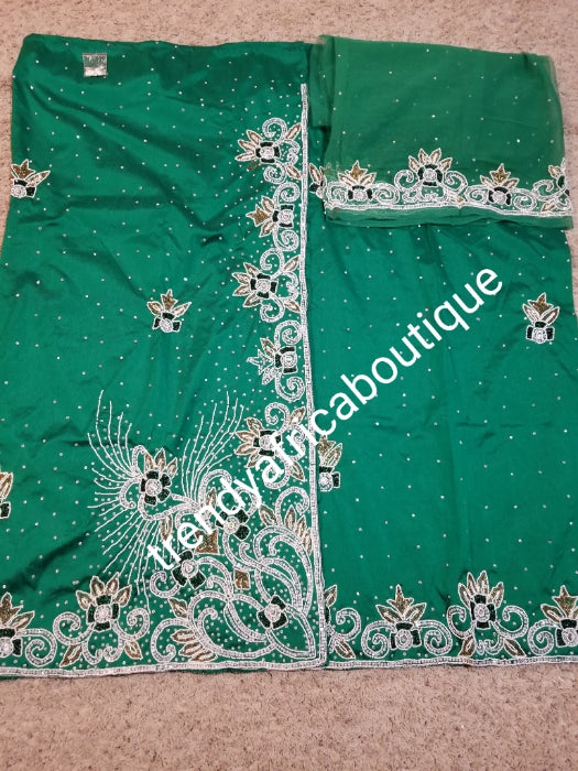 Special offer Nigerian Traditional wedding hand stoned Raw silk George Wrapper and matching net blouse. beautiful Green color embellished with crystal stones. Beaded and stoned on the side border top wrapper. Model shown wearing blue same design