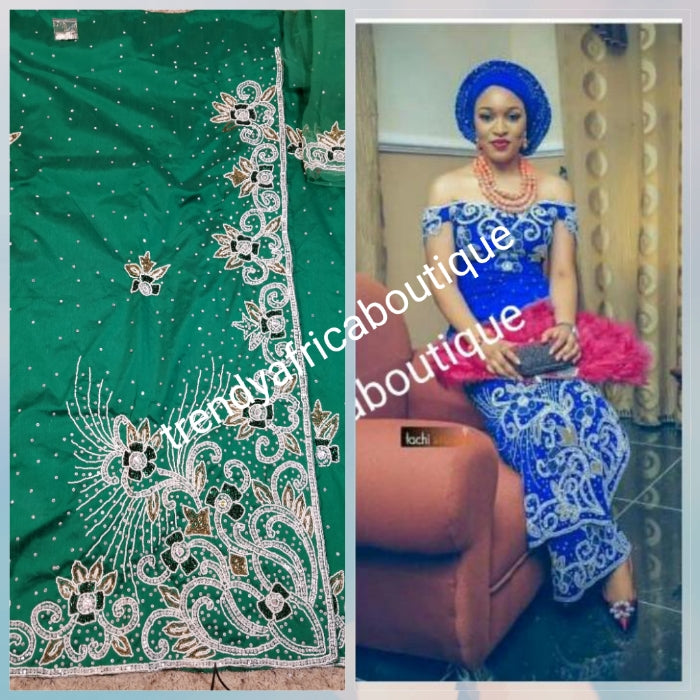 Special offer Nigerian Traditional wedding hand stoned Raw silk George Wrapper and matching net blouse. beautiful Green color embellished with crystal stones. Beaded and stoned on the side border top wrapper. Model shown wearing blue same design