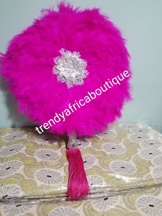 fluffy feather hand fan in beautiful fuchsia pink feathers, embellished with silver accessories. Nigerian traditional Bridal Accessories hand fan for celebrant. Fully handmade with silver handlel & matching pink tassels. Round fluffy feathers hand fan