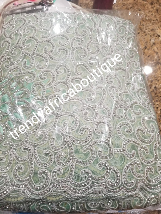 Mint Green/silver crystal hand stoned VIP celebrant George wrapper for Nigerian Ceremonies such as weddings. Igbo/Niger/ Delta/ wedding George. Set of Net + taffeta+ matching net for blouse. Breath taking crystal work!!! Model is wearing same design