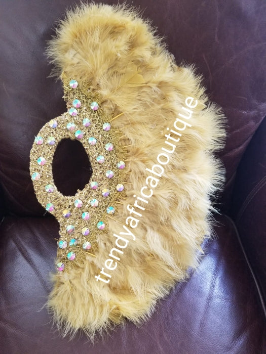 New arrival Pure Gold  feather hand fan. Large moon shape with handle. Nigerian  Bridal-accessories flower brooch front design. Embellished with sparkling crystal stones.. 25" long + 14" wide. Small handle to hold your fan.