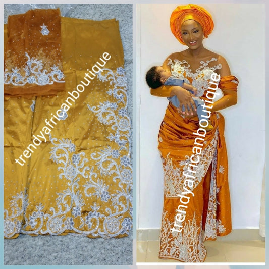 Exclusive design. Gold silk George wrapper beaded and stoned with white/silver. Nigetian traditional wedding George wrapper. Top quality at a special price. Sold 5yds +1.8yds matching net blouse